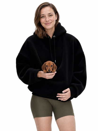 Woman wearing the black Puppy Pouch Hoodie with a dachshund puppy in the front carrier opening