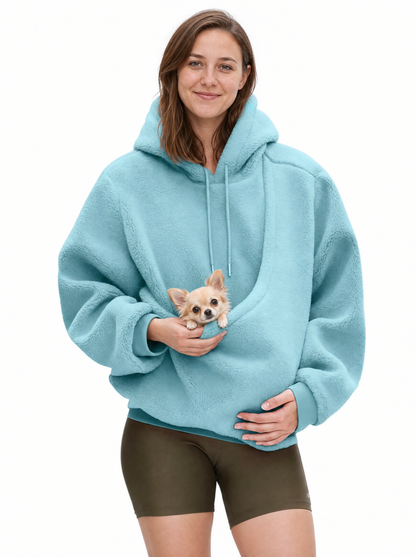 Woman wearing the sky blue Puppy Pouch Hoodie with a chihuahua puppy in the front carrier opening